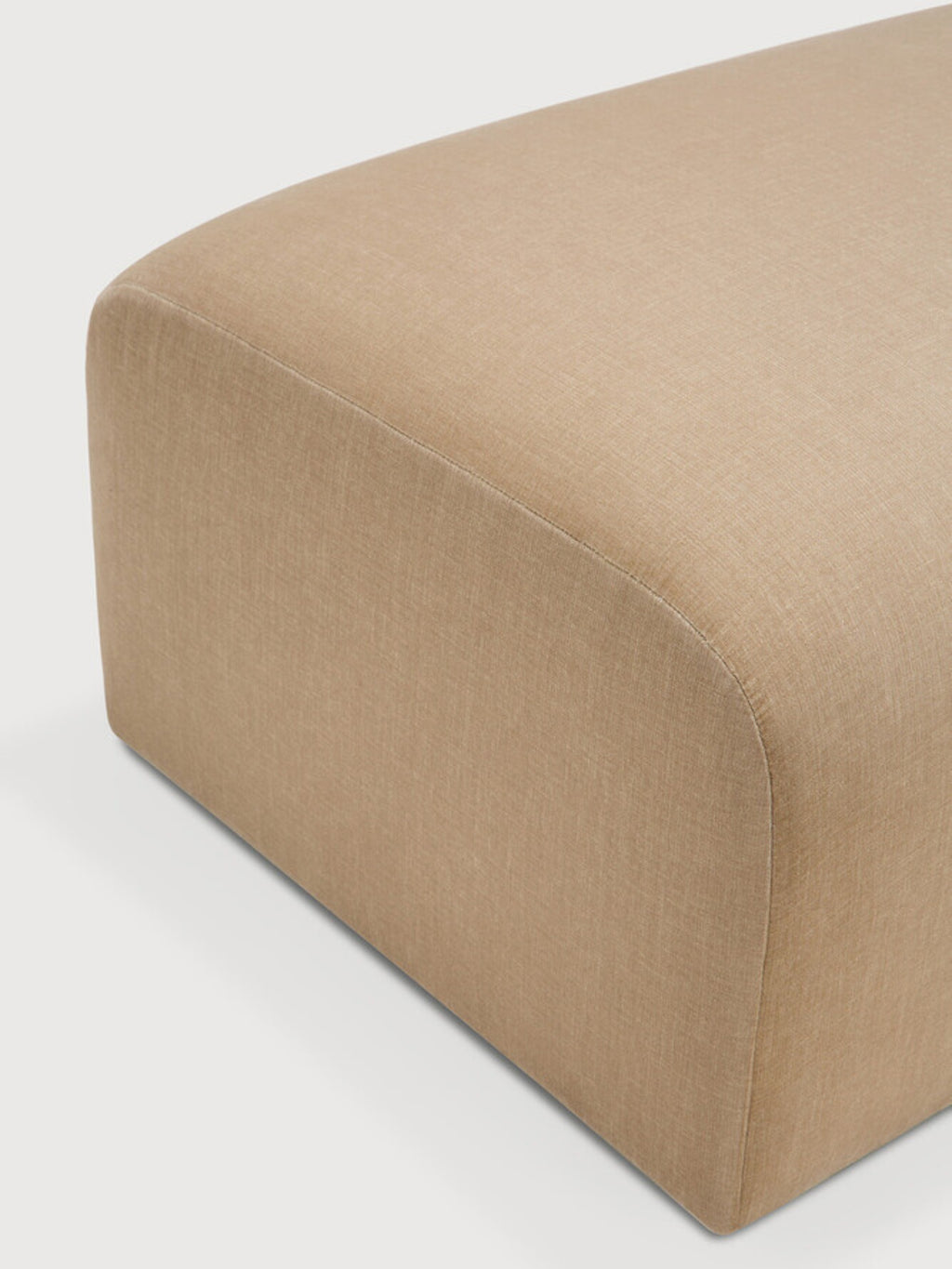 Ethnicraft Bulky Modular Sofa footstool module, a close-up detail of the premium beige fabric, highlighting the subtle texture and meticulous stitching along the rounded edge.