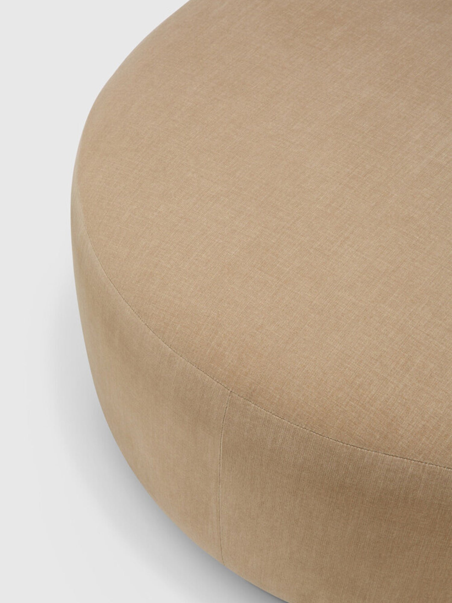 Ethnicraft Bulky Modular Sofa semi-circle footstool detail, showing the smooth, rounded form and subtle stitching of the plush beige fabric, on a light grey background.