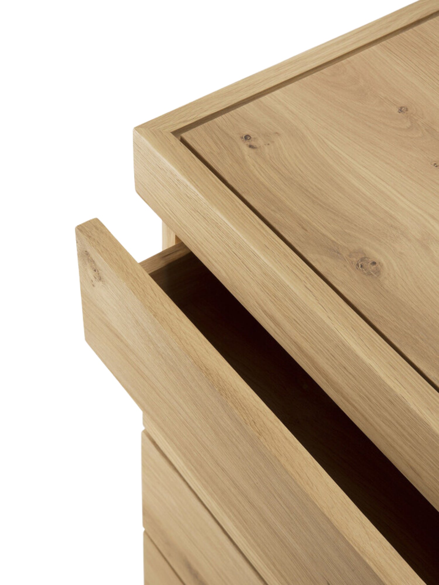 Ethnicraft Burger Dresser in Oak, a close-up view of the top drawer slightly ajar, revealing the smooth, light natural oak wood grain and precise craftsmanship of the modern design.