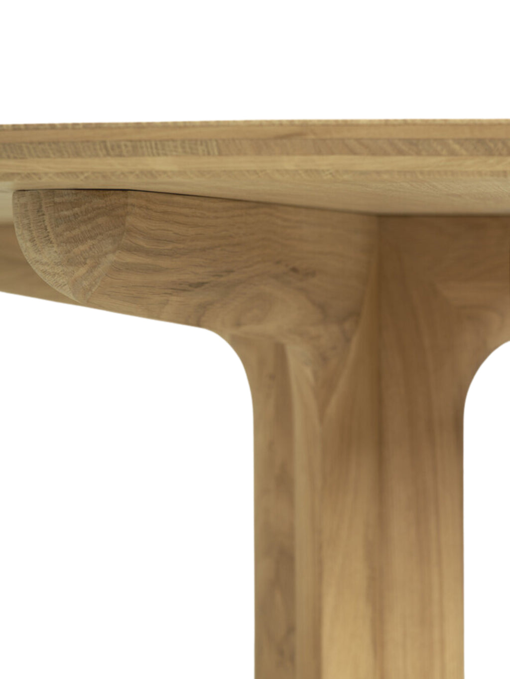 Ethnicraft Corto Dining Table, a round oak table, showcasing a detailed view of the smooth, light brown wooden leg structure and tabletop edge, displayed on a clean white background.