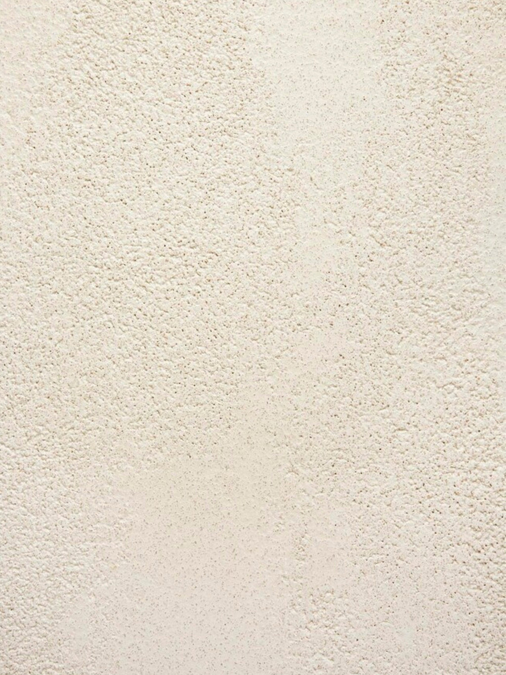 Ethnicraft Elements Console, a detailed view of the textured microcement surface. The light, natural beige color and subtle, tactile pattern of the material are clearly visible, emphasizing its unique finish.