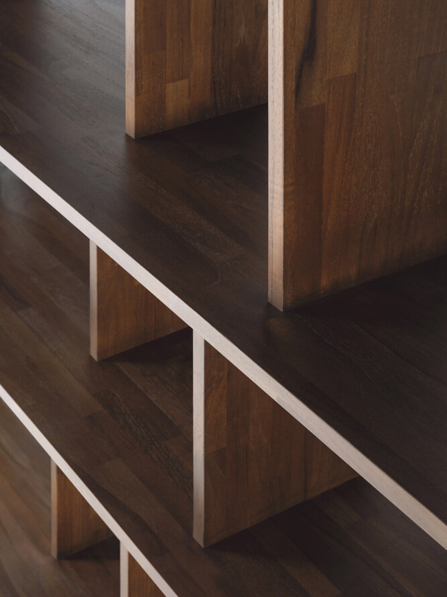 Ethnicraft Irregular Rack in Teak Brown, a close-up showing the elegant joinery and the varied depths of the dark teak wood shelves, highlighting its premium craftsmanship.