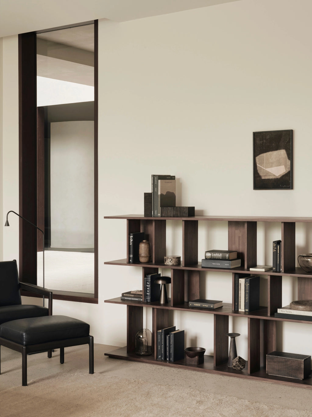 Ethnicraft Irregular Rack in Teak Brown, a stylish and functional wooden bookcase filled with books and decorative objects, enhancing a contemporary living room setting.