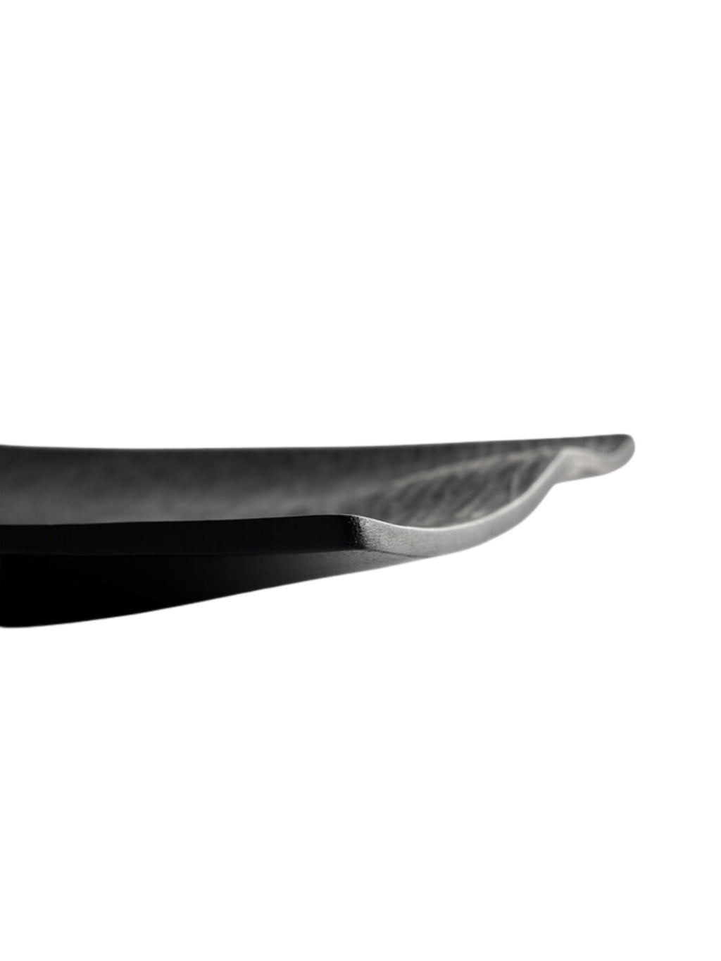 Ethnicraft Japan Board, a side profile view of the black serving board, highlighting its subtle upward curve and thin, elegant silhouette. The textured surface is visible, adding depth to this modern and functional design, displayed on a white background.