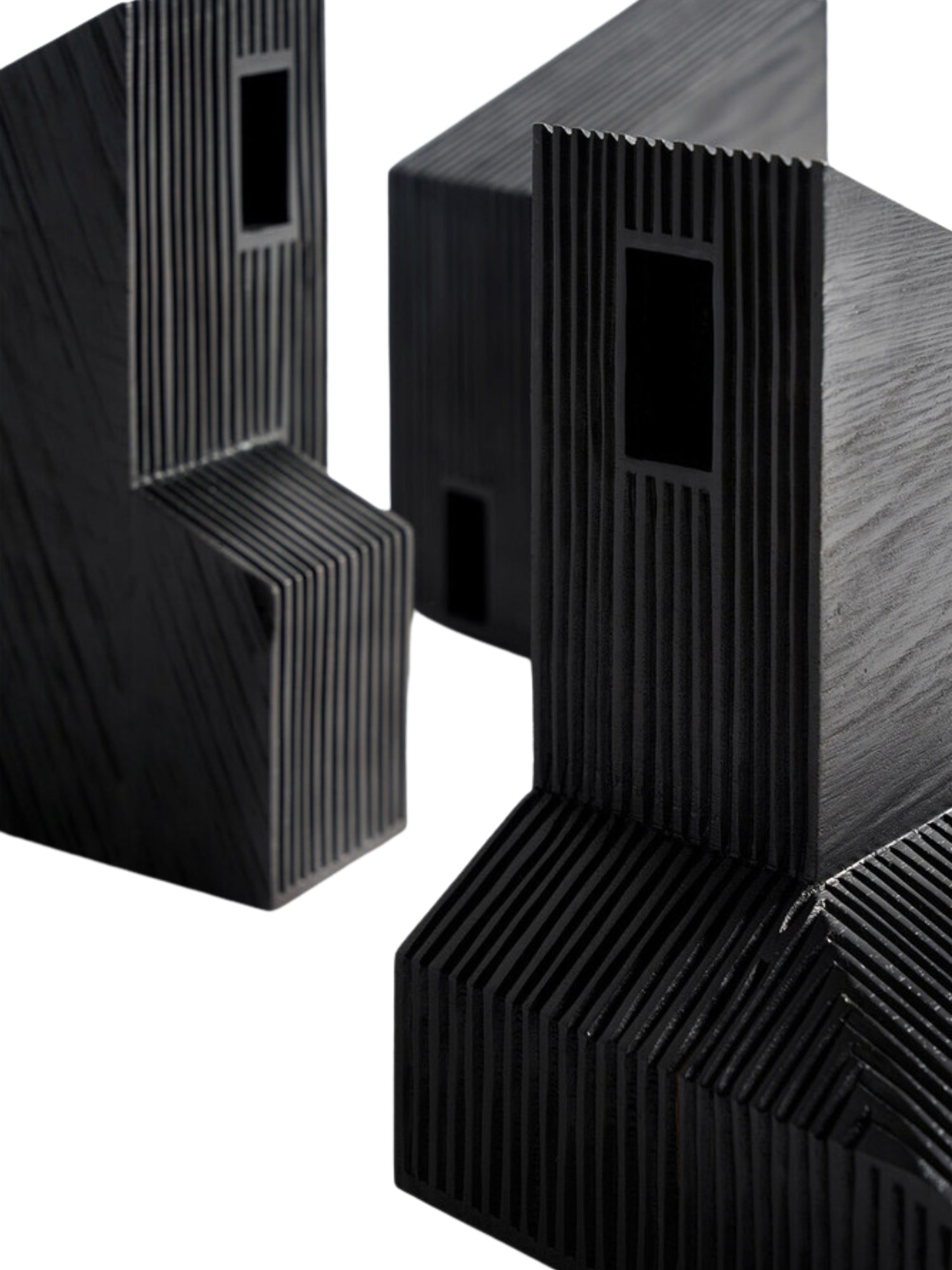 Ethnicraft Modern Farmhouse Object, a detailed perspective of two black wooden sculptures, revealing their geometric shapes and the rich, textured grain of the wood with distinct vertical ridges, against a white background.