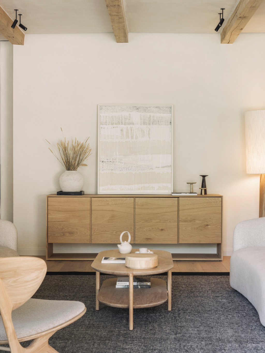 Ethnicraft Nordic Sideboard in a cozy, elegant living room, showcasing its natural oak wood texture, adorned with decorative vases, artwork, and a coffee table, creating a warm, inviting atmosphere.