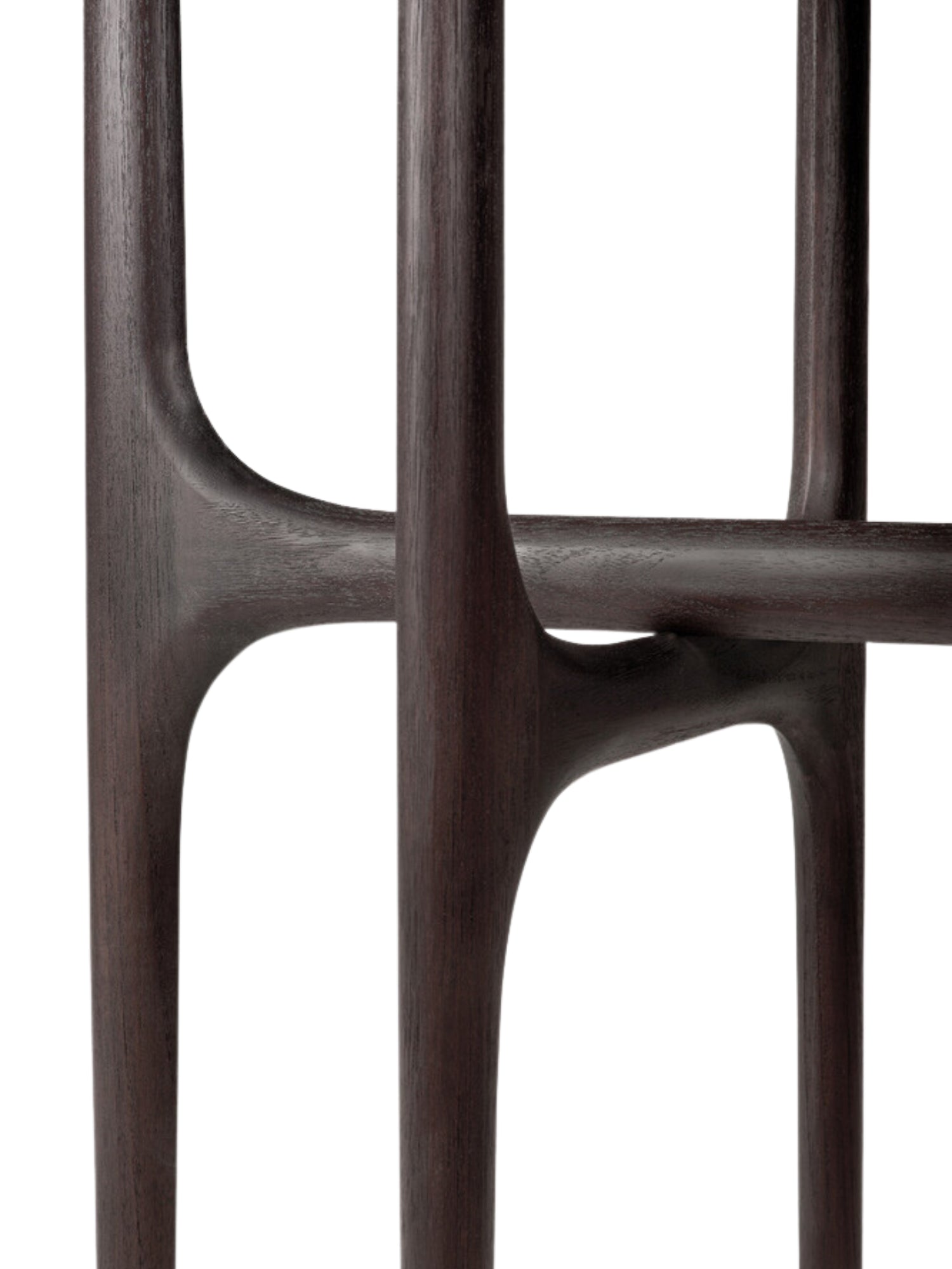 Ethnicraft PI Console, a close-up detail of the dark brown teak wood frame. The image highlights the organic, sculptural lines and smooth finish of the console's legs and supports, showcasing the exquisite craftsmanship and natural beauty of the wood.