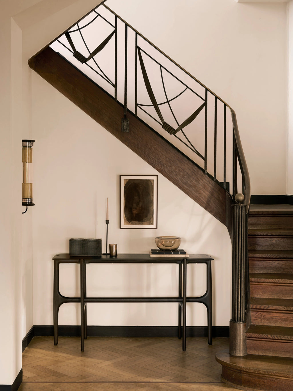 Ethnicraft PI Console in dark brown teak, a modern, elegant console table with a minimalist design, featuring a smooth, rich wood grain finish, styled in a luxurious entryway with a staircase.