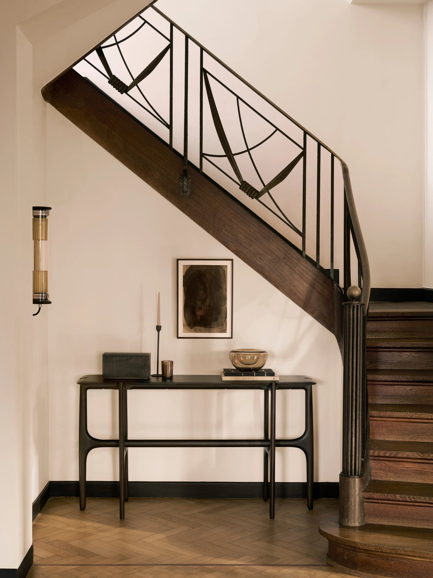 Ethnicraft PI Console in dark brown teak, a modern, elegant console table with a minimalist design, featuring a smooth, rich wood grain finish, styled in a luxurious entryway with a staircase.
