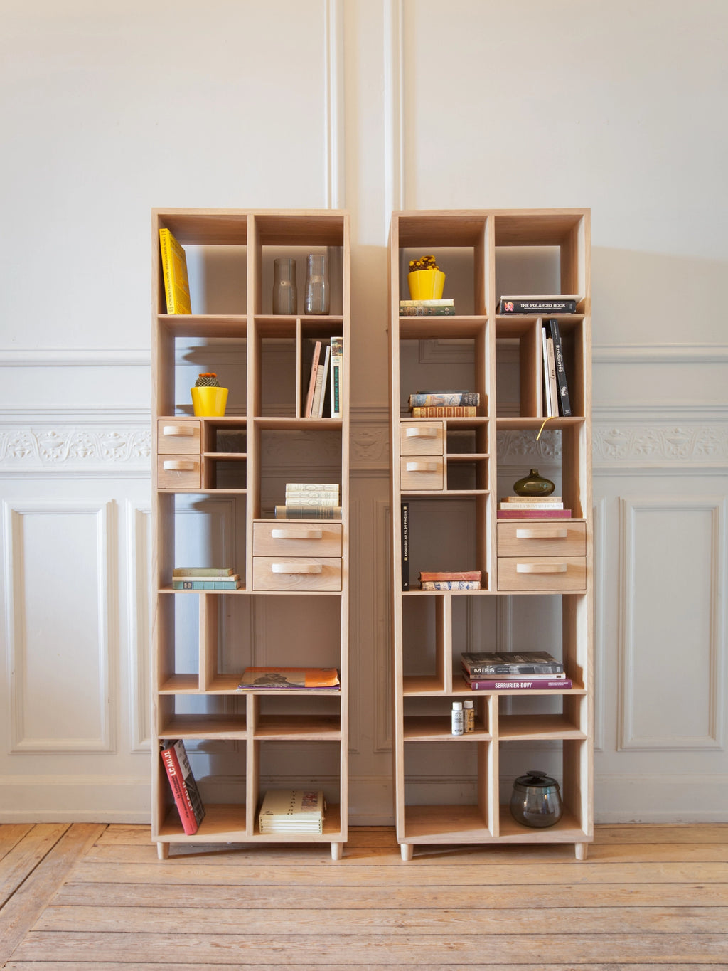 Ethnicraft Pirouette Rack, a modern oak shelving unit with multiple open compartments and small drawers, showcasing a light wood grain texture, styled in a bright, minimalist living space.