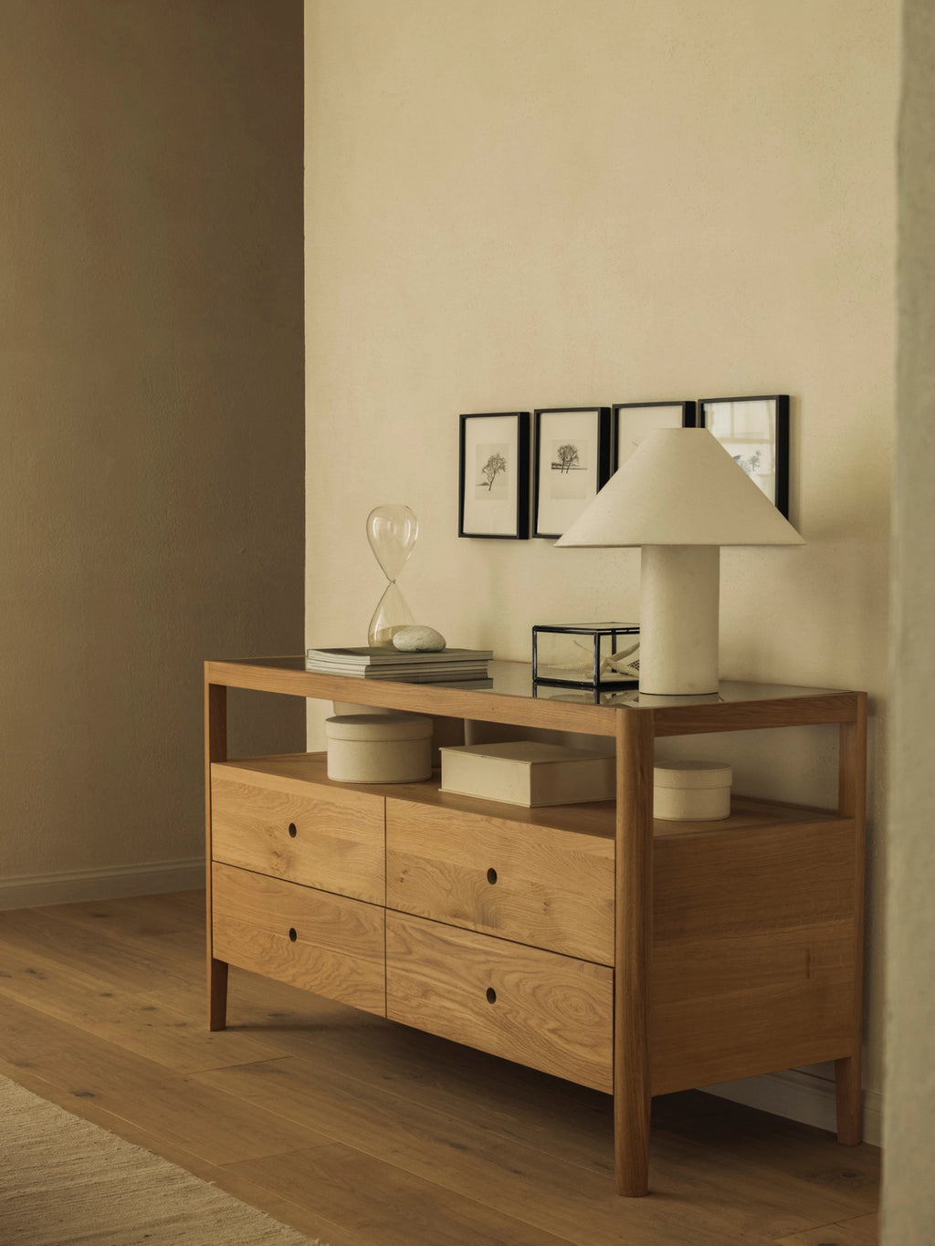 Ethnicraft Spindle Dresser in natural oak, styled in a modern bedroom setting with a lamp, framed art, and decorative objects, exuding a warm, inviting ambiance.