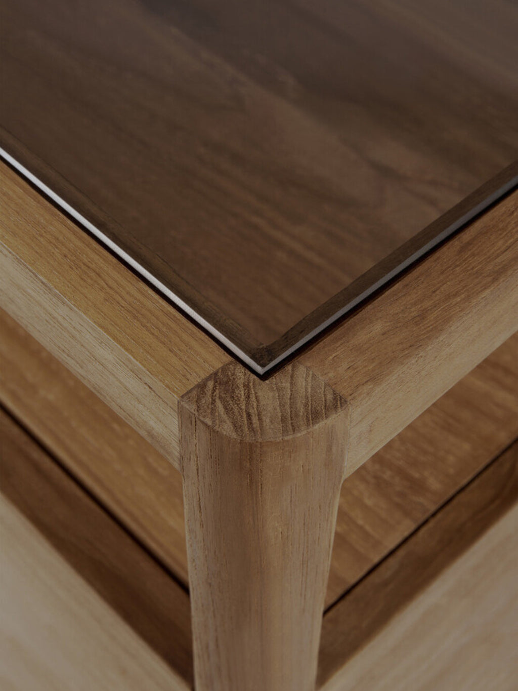 Ethnicraft Spindle Dresser in light oak, highlighting a corner detail with a smooth glass top and sturdy, rounded wooden legs, providing a modern, elegant aesthetic.