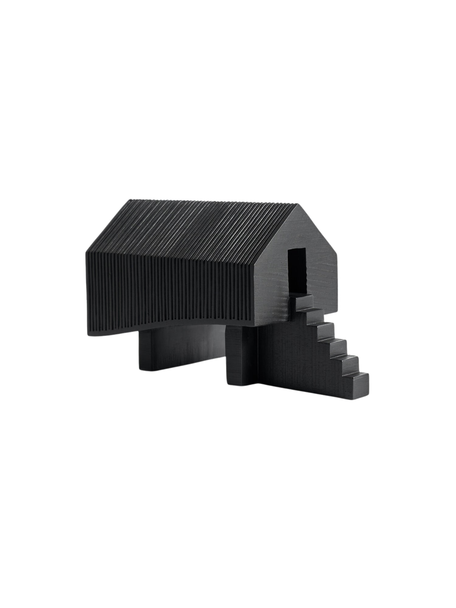 Ethnicraft Stilt House Object. Front view of the minimalist dark black wooden house sculpture, featuring a ribbed roof and side, an open doorway, and integrated stairs, presented on a crisp white background.