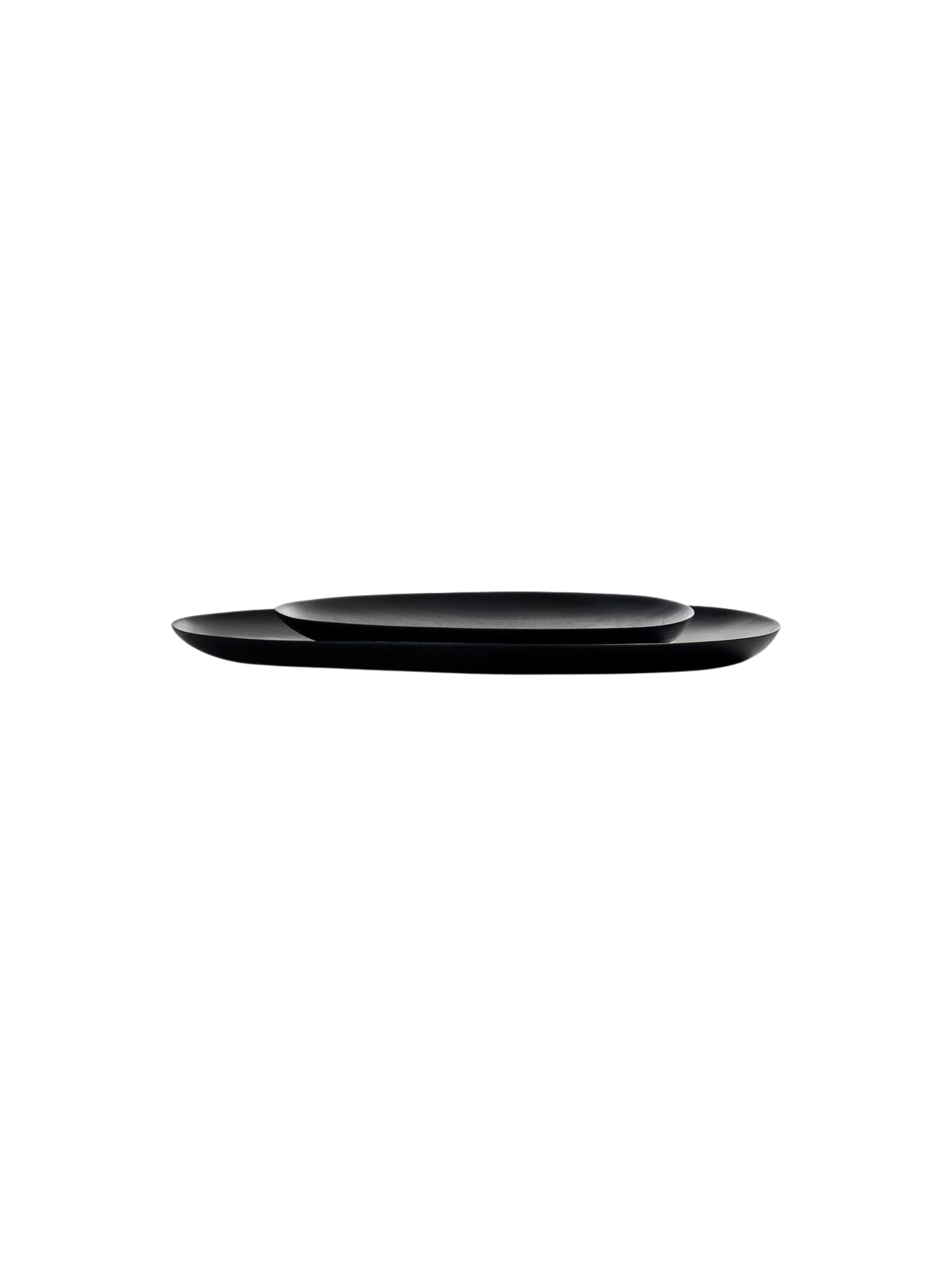 Ethnicraft Thin Oval Boards Set. A pair of sleek, minimalist dark black mahogany oval serving boards, stacked elegantly to showcase their thin profile and smooth, refined finish, displayed on a clean white background.