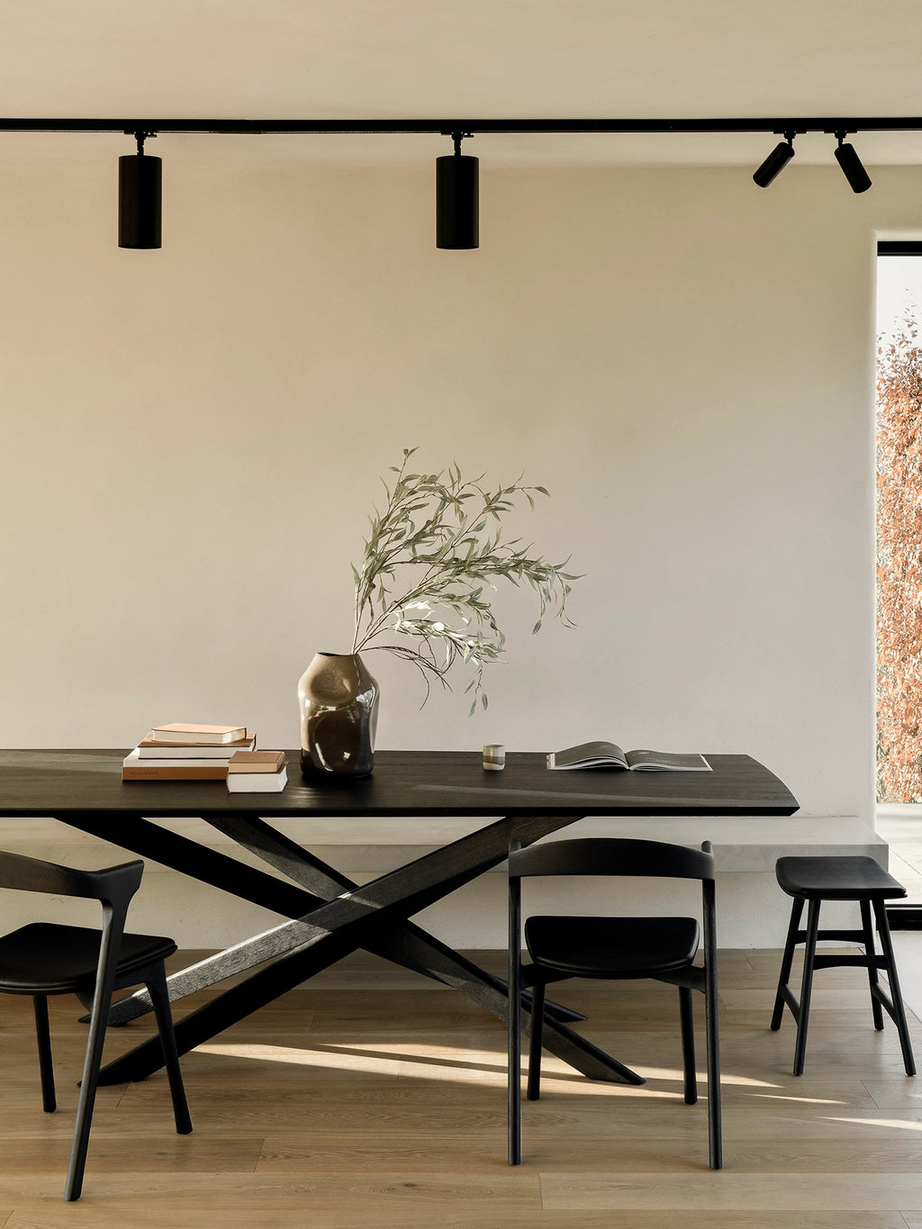 Ethnicraft Mikado Dining Table, a striking modern dining table crafted from solid black oak wood, featuring a rectangular tabletop and a distinctive criss-cross X-shaped base. This minimalist yet sculptural design showcases the rich texture of black oak. Ideal for contemporary dining rooms, open-plan living spaces, or Japandi-inspired interiors.