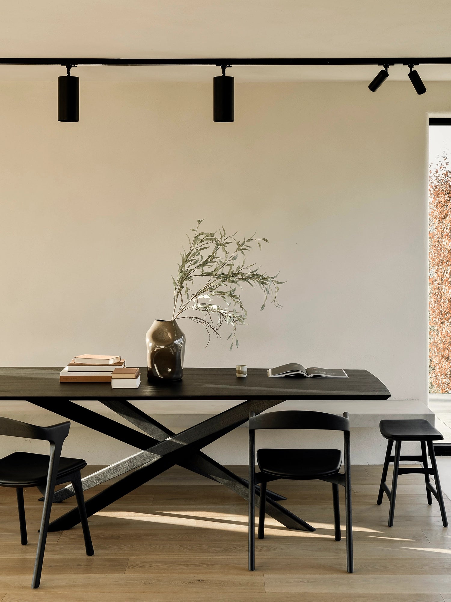 Ethnicraft Mikado Dining Table, a striking modern dining table crafted from solid black oak wood, featuring a rectangular tabletop and a distinctive criss-cross X-shaped base. This minimalist yet sculptural design showcases the rich texture of black oak. Ideal for contemporary dining rooms, open-plan living spaces, or Japandi-inspired interiors.