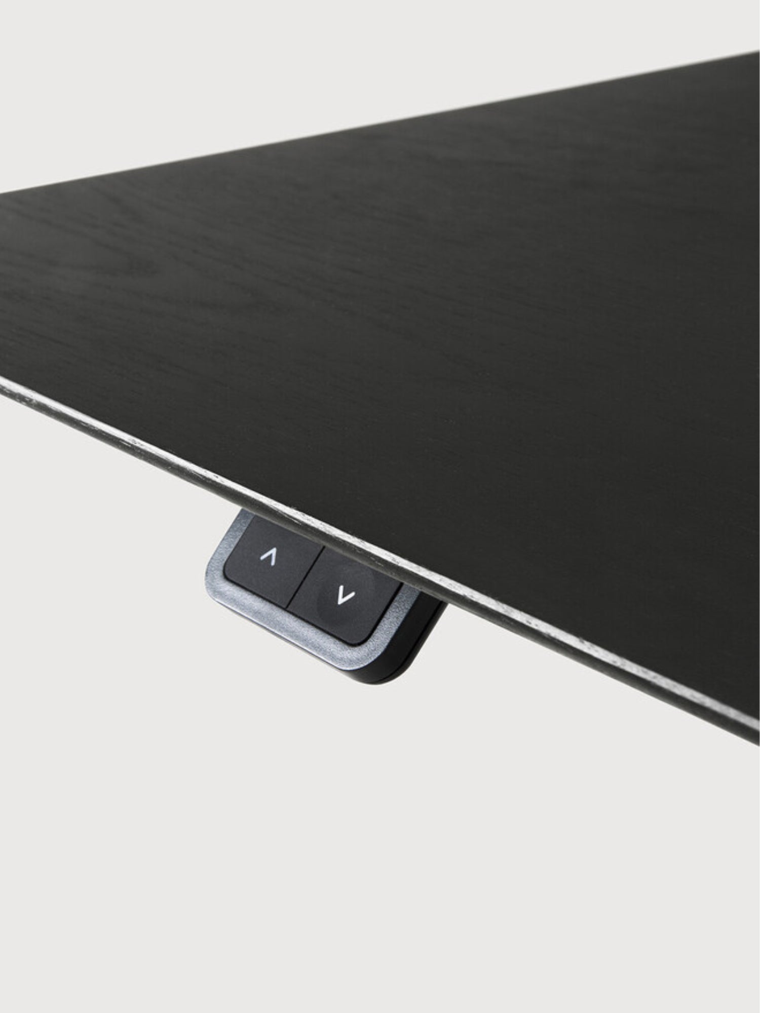 Ethnicraft Bok Adjustable Desk with black oak tabletop and black frame, a close-up from below showing the discreet control panel with up/down arrows, seamlessly integrated into the desk's underside.