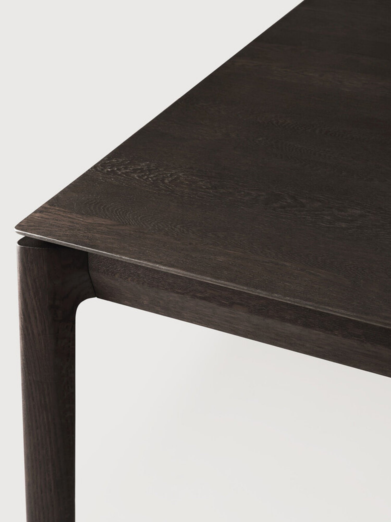 Ethnicraft Bok Dining Table, close-up of dark brown oak wood tabletop and leg joint, 220cm.