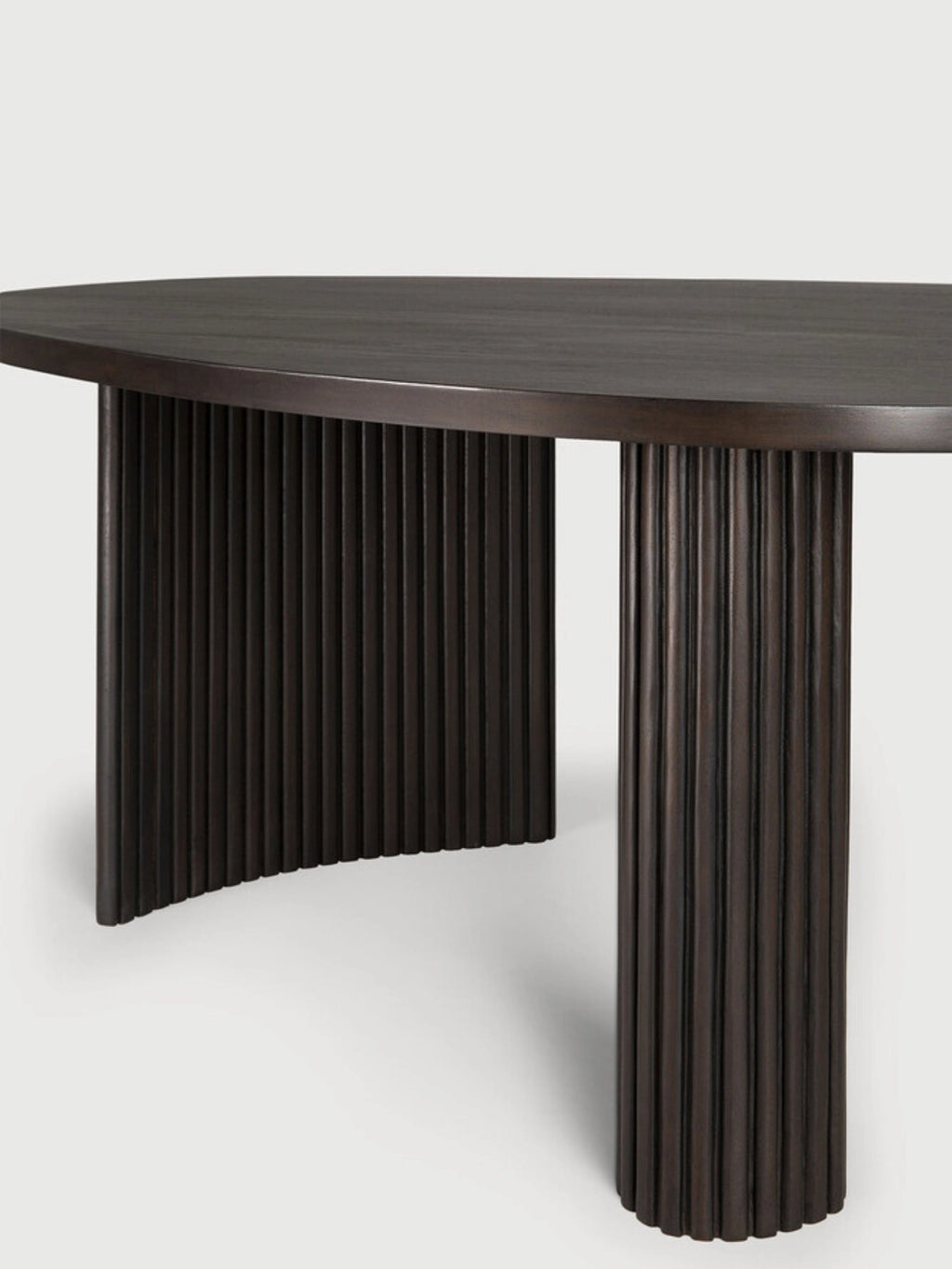Ethnicraft Boomerang Coffee Table in dark brown mahogany, showcasing the elegant curved tabletop and fluted cylindrical legs, displayed on a clean white background.
