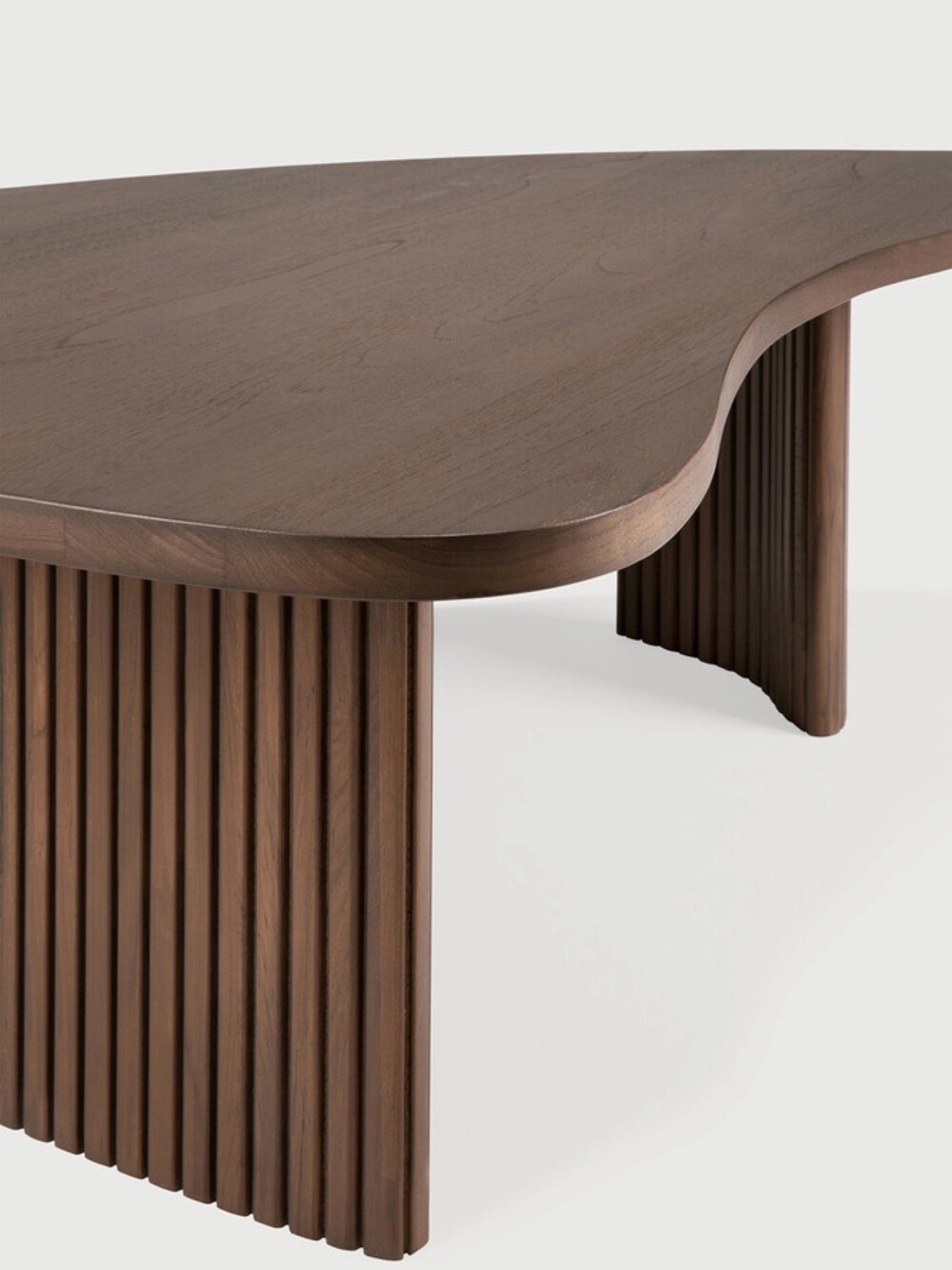 Ethnicraft Boomerang Coffee Table in rich brown teak wood, featuring a detailed view of its unique organic, kidney-shaped top and the distinctive fluted, curved leg structure, on a white background.