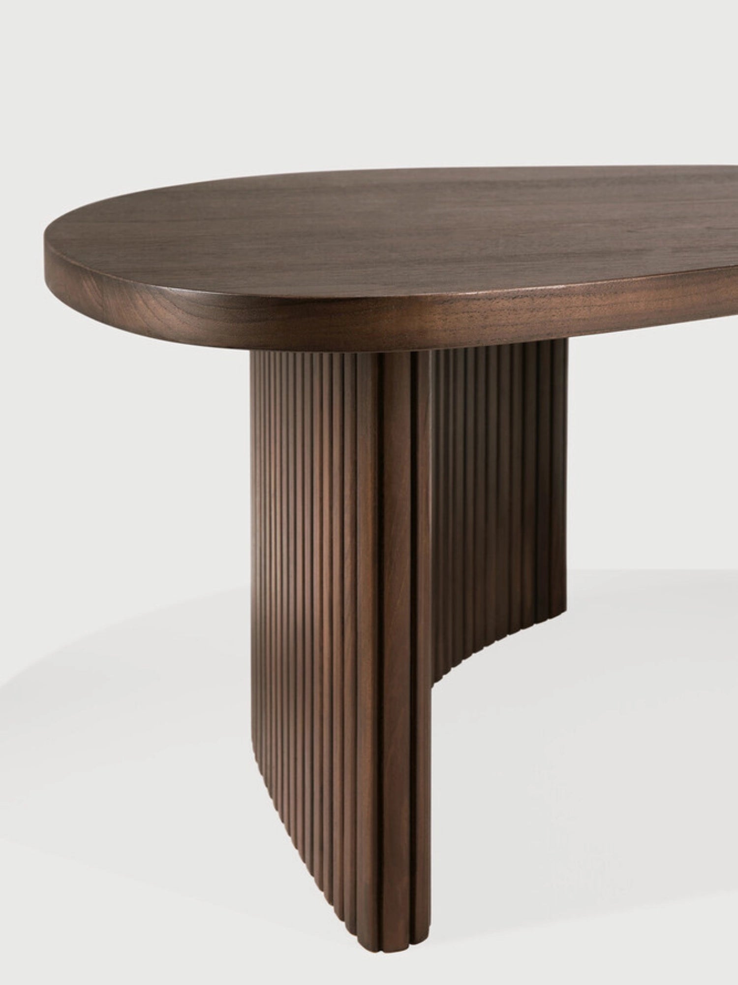 Ethnicraft Boomerang Coffee Table in dark brown teak, showcasing a close-up of the elegant curved tabletop and the ribbed, fluted base design, displayed on a clean white background.