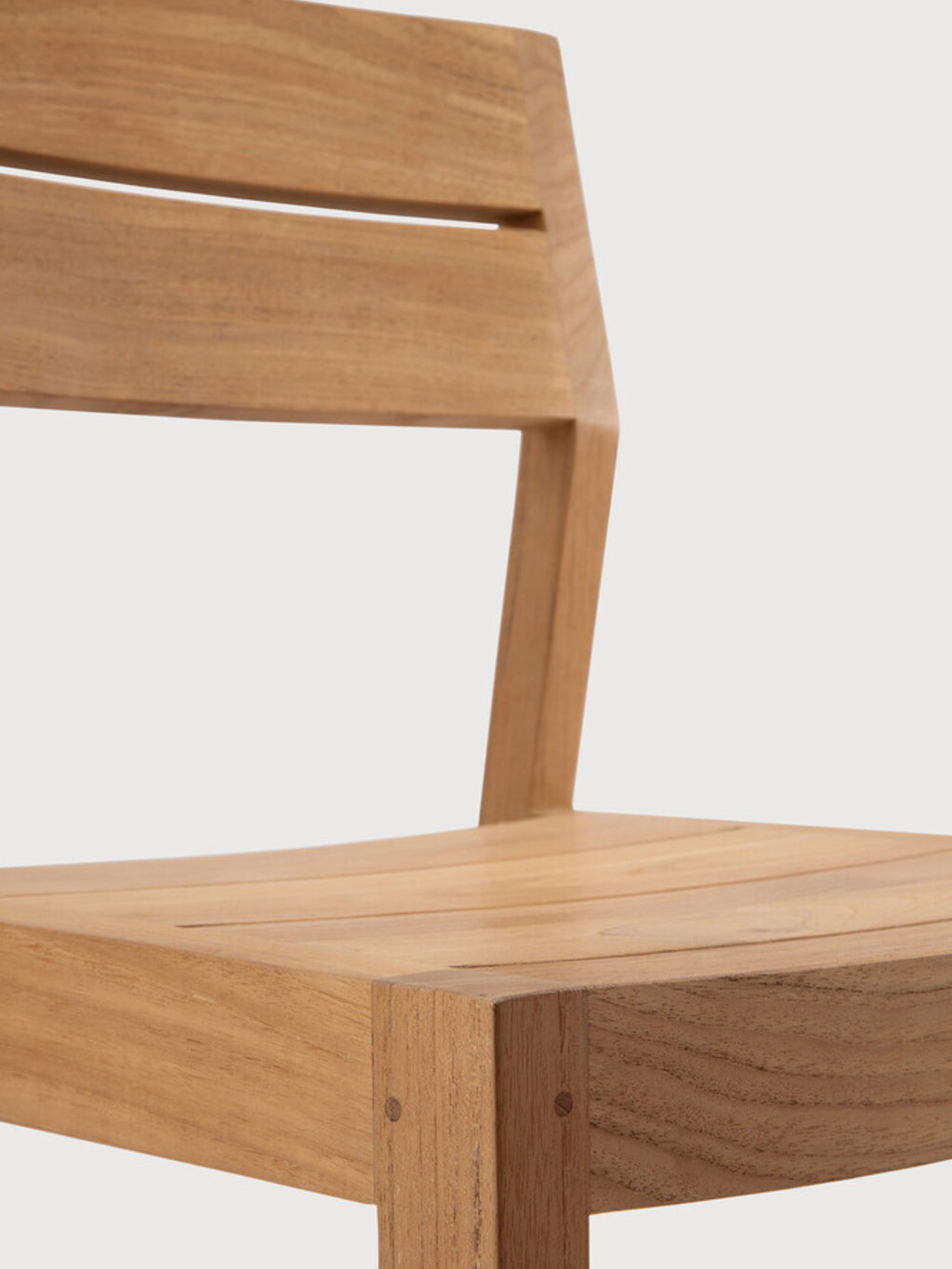 Ethnicraft EX1 Outdoor Dining Chair, a modern minimalist chair crafted from durable, honey-toned solid teak wood with a smooth, naturally textured grain.