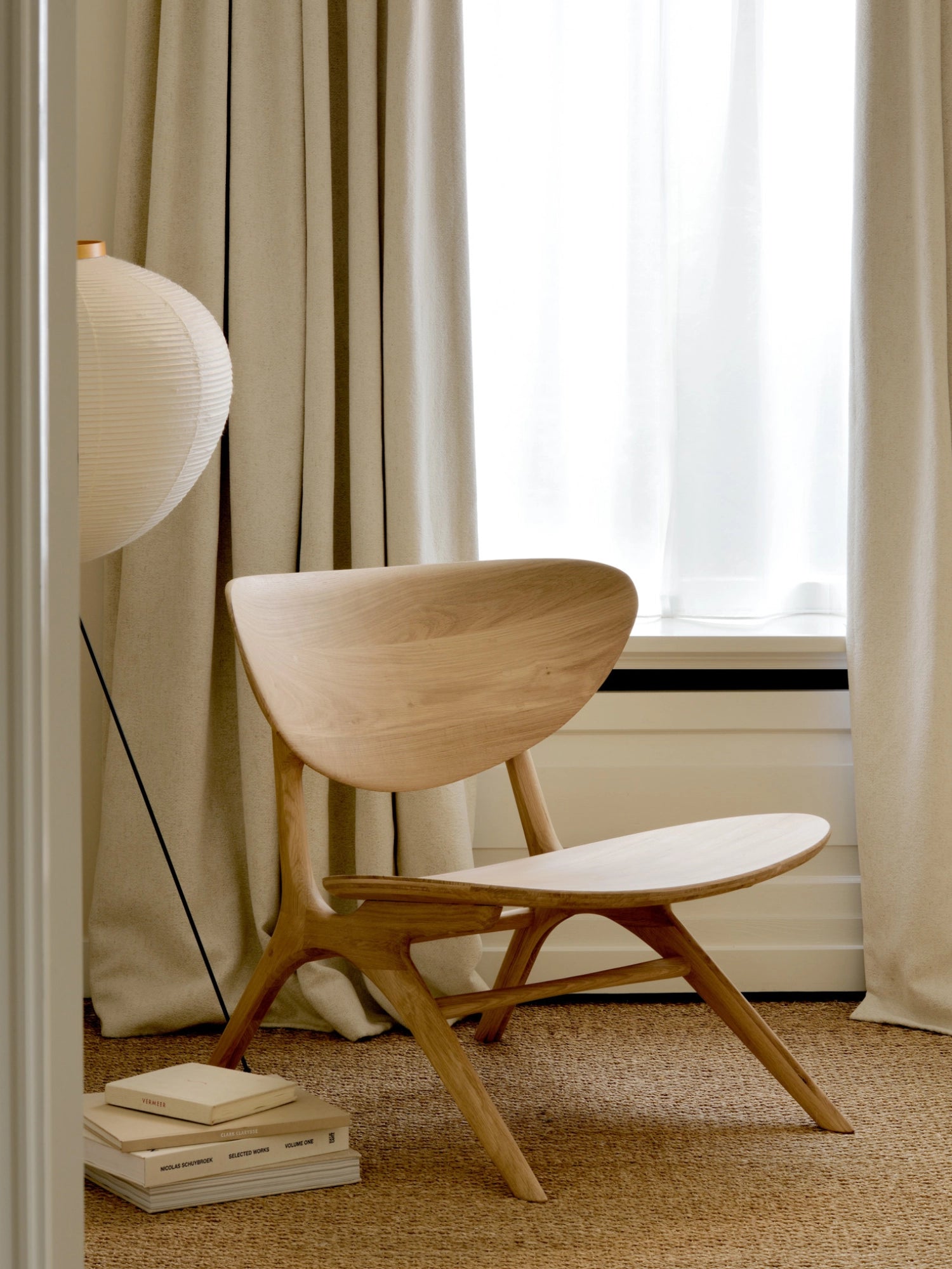 Ethnicraft Eye Lounge Chair, a sculptural and contemporary lounge chair crafted from light natural solid wood, featuring a beautifully curved, organic seat and backrest with a smooth, minimalist design. Its elegant angled legs and warm wood tones embody Scandinavian and organic modern aesthetics. Ideal as a stylish accent chair for a modern living room, bedroom, or a cozy reading nook.