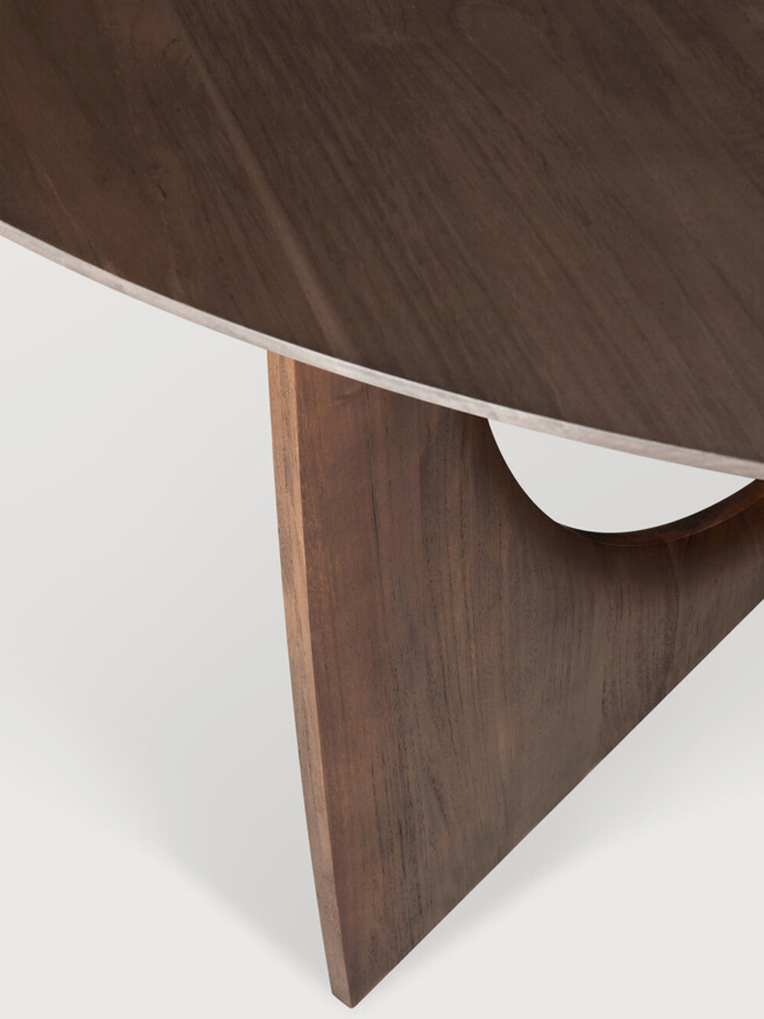Ethnicraft Geometric Dining Table, a contemporary solid wood dining table crafted from rich dark walnut with a smooth, visible grain, featuring a sleek round tabletop and a sculptural geometric base with a triangular leg and an organic curved cut-out. Ideal for modern dining rooms, minimalist interiors, and sophisticated kitchen areas.