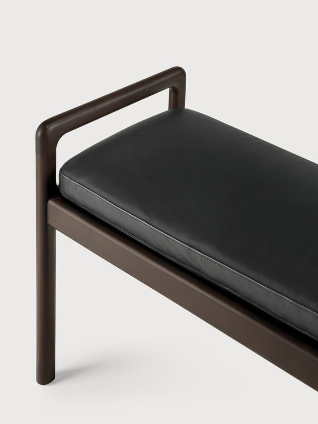 Ethnicraft Jack Bench, a detailed view of the elegant mahogany dark brown wooden frame and the supple black leather cushion, emphasizing the refined craftsmanship and modern aesthetic.