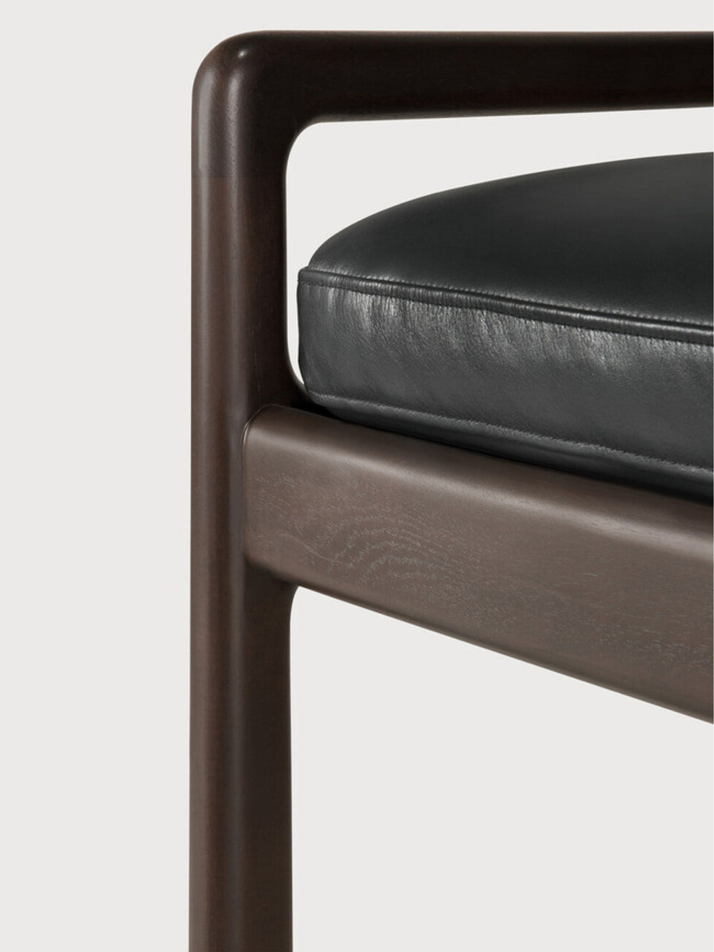 Ethnicraft Jack Bench, a close-up detail of the mahogany dark brown wooden frame and the sleek black leather cushion, highlighting the smooth finish and luxurious feel.