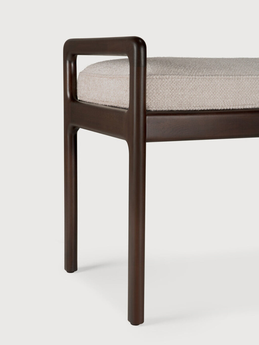 Ethnicraft Jack Bench, a close-up detail of the sturdy mahogany dark brown wooden leg and armrest, paired with the textured ivory fabric cushion, on a clean white background.