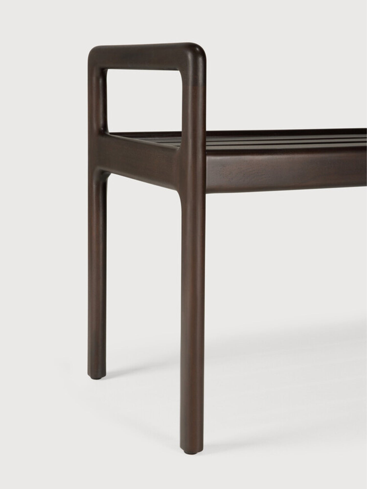 Ethnicraft Jack Bench in mahogany dark brown, a close-up detail of the leg and armrest, showcasing the sturdy construction and the elegant, minimalist design of the wooden frame.