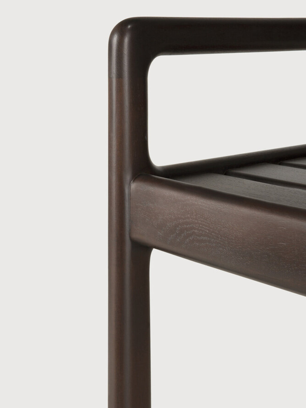 Ethnicraft Jack Bench in mahogany dark brown, a detailed view focusing on the smooth, rounded corner of the armrest and leg, highlighting the premium craftsmanship and wood finish.