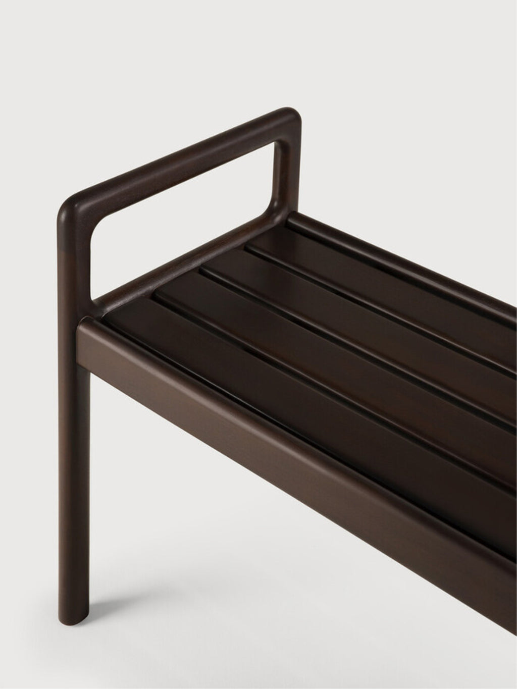 Ethnicraft Jack Bench in mahogany dark brown, a close-up detail shot showcasing the elegant slatted wooden seat and the smooth, rounded edges of the armrests and legs.