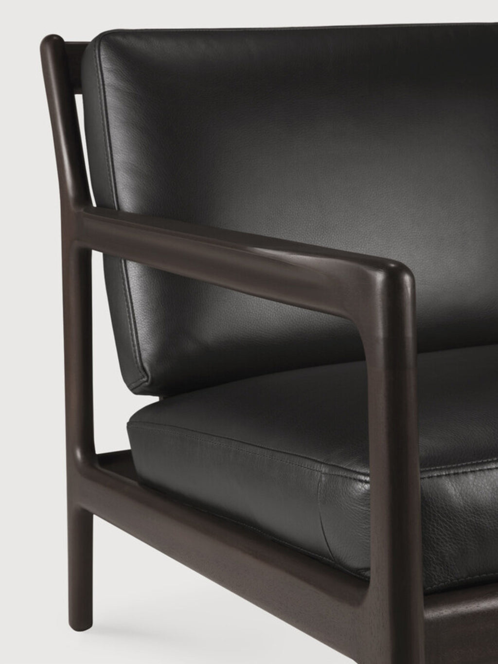 Ethnicraft Jack Lounge Chair, a modern minimalist armchair featuring a dark solid wood frame with elegantly curved armrests and legs, complemented by plush black leather upholstery. This contemporary lounge chair offers sophisticated comfort with its clean lines and rich materials. Perfect as an accent chair for a stylish living room, reading nook, or bedroom.
