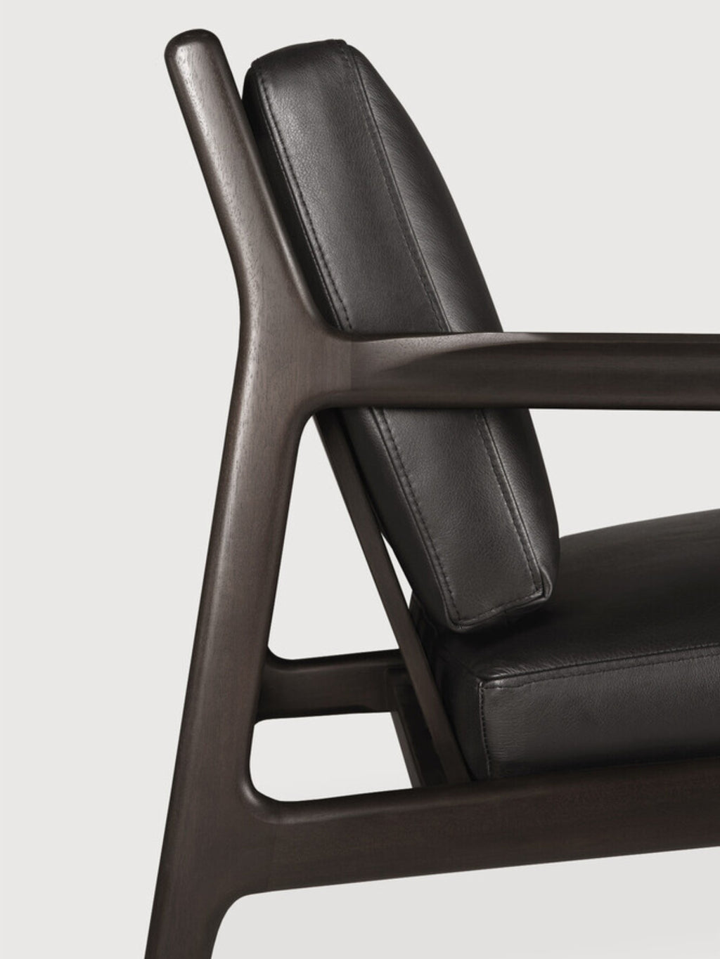 Ethnicraft Jack Lounge Chair, a sophisticated mid-century modern lounge chair featuring a dark stained solid wood frame with gracefully curved armrests and an ergonomic backrest, complemented by plush black leather upholstered cushions. This contemporary armchair offers luxurious comfort and timeless Scandinavian design, perfect for a modern living room, elegant reading nook, or chic bedroom accent.
