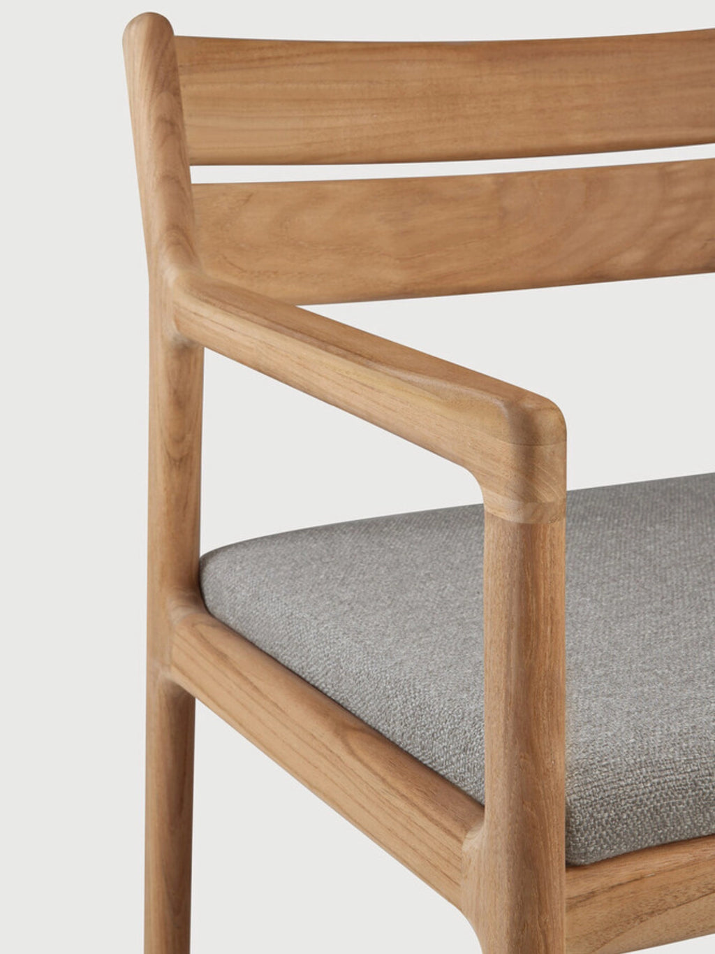 Ethnicraft Jack Outdoor Dining Chair With Armrest, a modern minimalist outdoor dining chair crafted from natural solid teak wood with a smooth finish and a light grey upholstered seat cushion. This contemporary armchair features clean lines, a slatted backrest, and gently rounded armrests, showcasing the beautiful wood grain. Perfect for elegant outdoor dining areas, patios, or garden spaces seeking Scandinavian-inspired furniture.