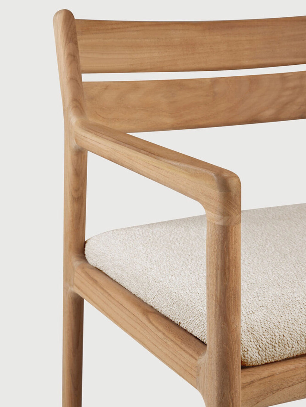 Ethnicraft Jack Outdoor Dining Chair With Armrest, a modern minimalist outdoor armchair crafted from durable solid teak wood with a natural light brown finish and gracefully rounded edges. This contemporary dining chair features a comfortable cream-colored, textured bouclé-style fabric cushion and a clean slatted backrest. It is ideal for sophisticated outdoor dining areas, patios, and garden spaces seeking sustainable teak furniture.