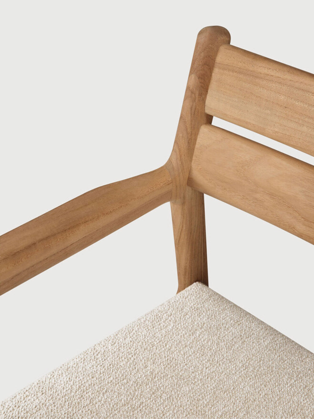 Ethnicraft Jack Outdoor Dining Chair With Armrest, a modern minimalist outdoor dining chair crafted from durable natural solid teak wood with a smooth, rounded frame and a slatted backrest. It features a comfortable light cream textured upholstered seat designed for outdoor use. This Scandinavian-inspired teak patio chair is perfect for contemporary garden dining and stylish outdoor living spaces.