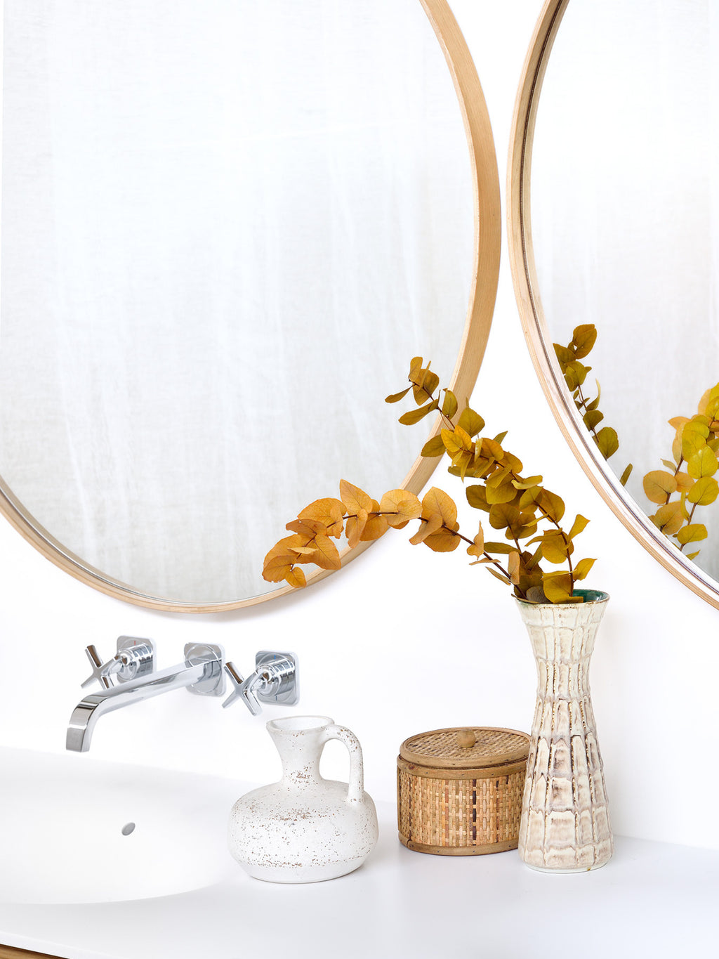 Ethnicraft Layers Wall Mirror, a minimalist round wall mirror featuring a slender natural light oak wood frame, designed to be displayed individually or artfully overlapped for a layered effect.