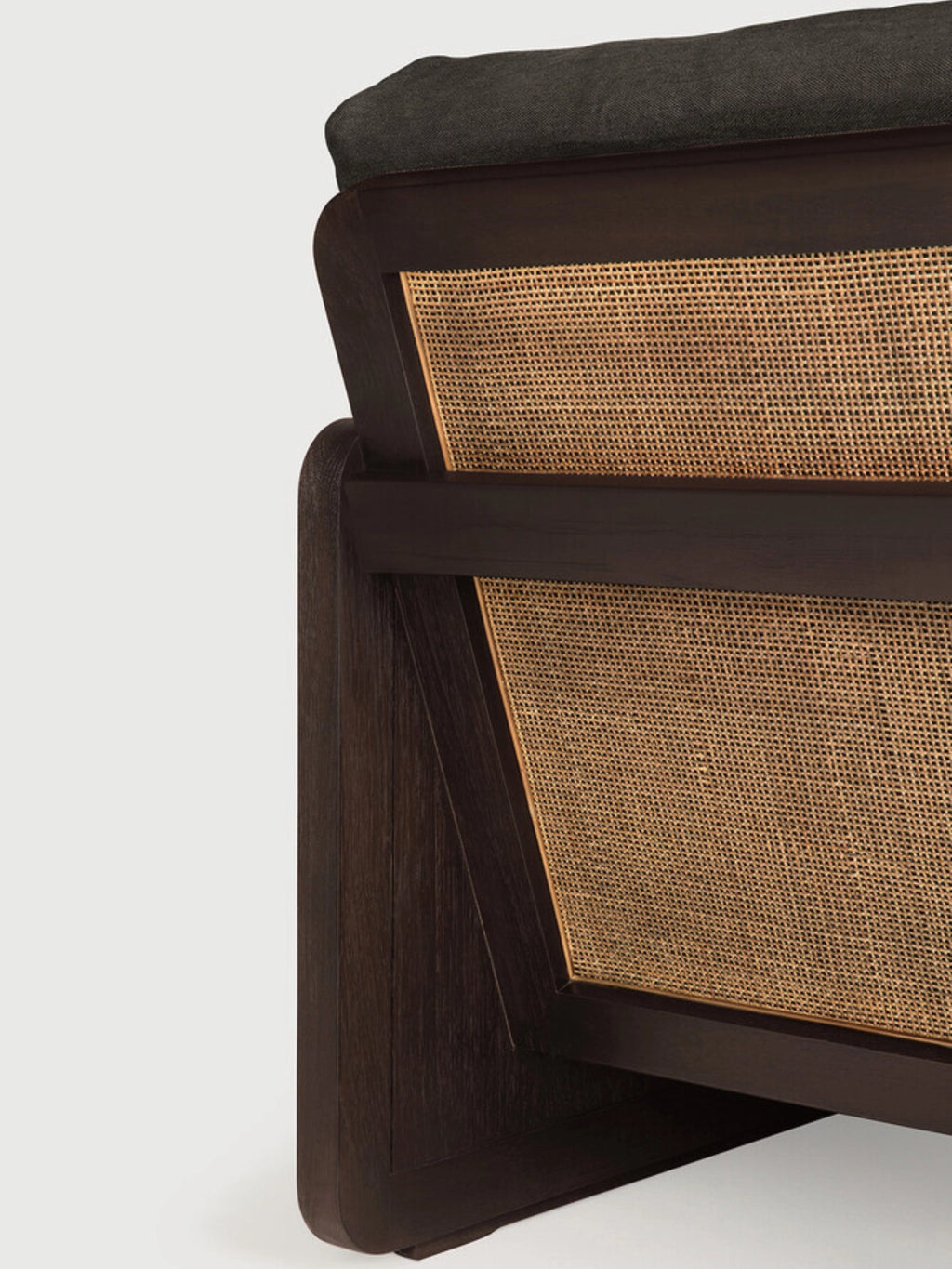 Ethnicraft Panel Lounge Chair, a sophisticated modern lounge chair featuring a dark solid wood frame with a rich, deep brown finish and beautifully integrated woven cane panels on the back. It includes a plush, dark grey upholstered cushion for comfort, blending organic modern and contemporary design aesthetics.