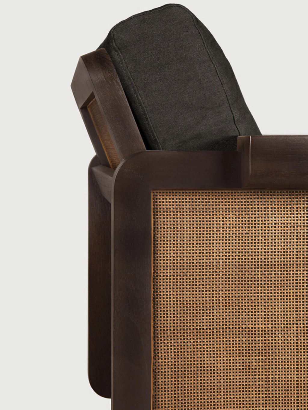 Ethnicraft Panel Lounge Chair, a sophisticated mid-century modern lounge chair featuring a rich dark brown solid wood frame with elegant rounded edges and natural hand-woven cane panels. It includes a plush dark charcoal grey fabric cushion for comfort, blending organic modern aesthetics with contemporary design. Ideal as a stylish accent chair for living rooms, studies, or bedrooms.