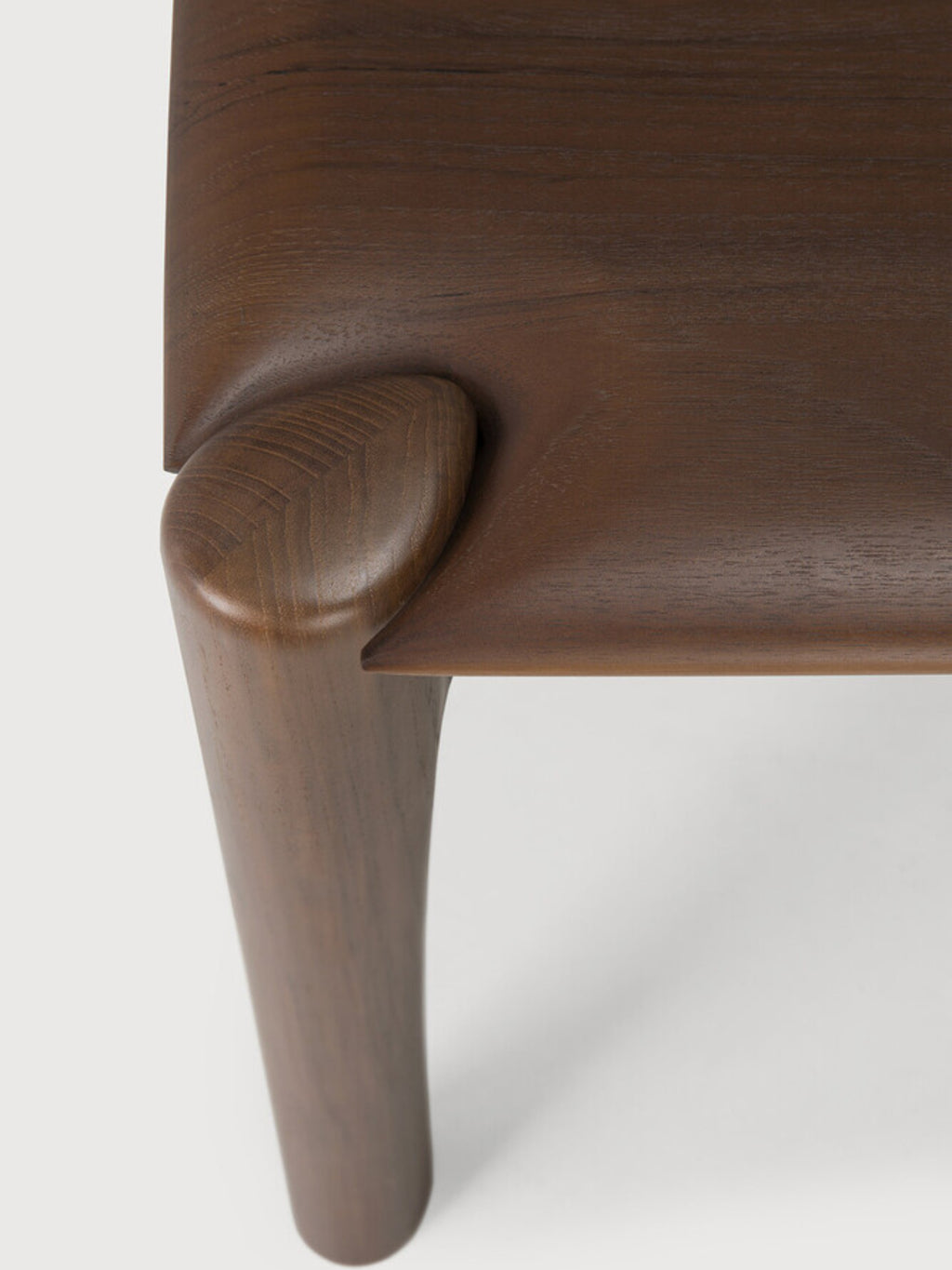 Ethnicraft PI Bench, a detailed view of the dark brown teak wood, highlighting the seamless joint between the leg and seat, demonstrating its sturdy and elegant construction.