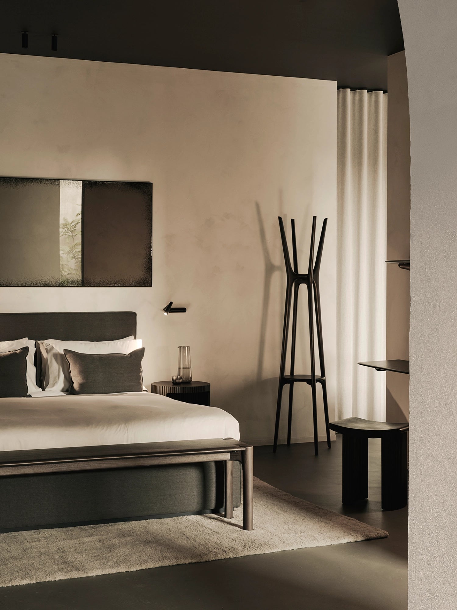 Ethnicraft PI Coat Stand, a sculptural modern coat rack crafted from dark solid wood with a matte black finish, featuring a robust, architectural silhouette with multiple upward-reaching prongs and a lower integrated circular.