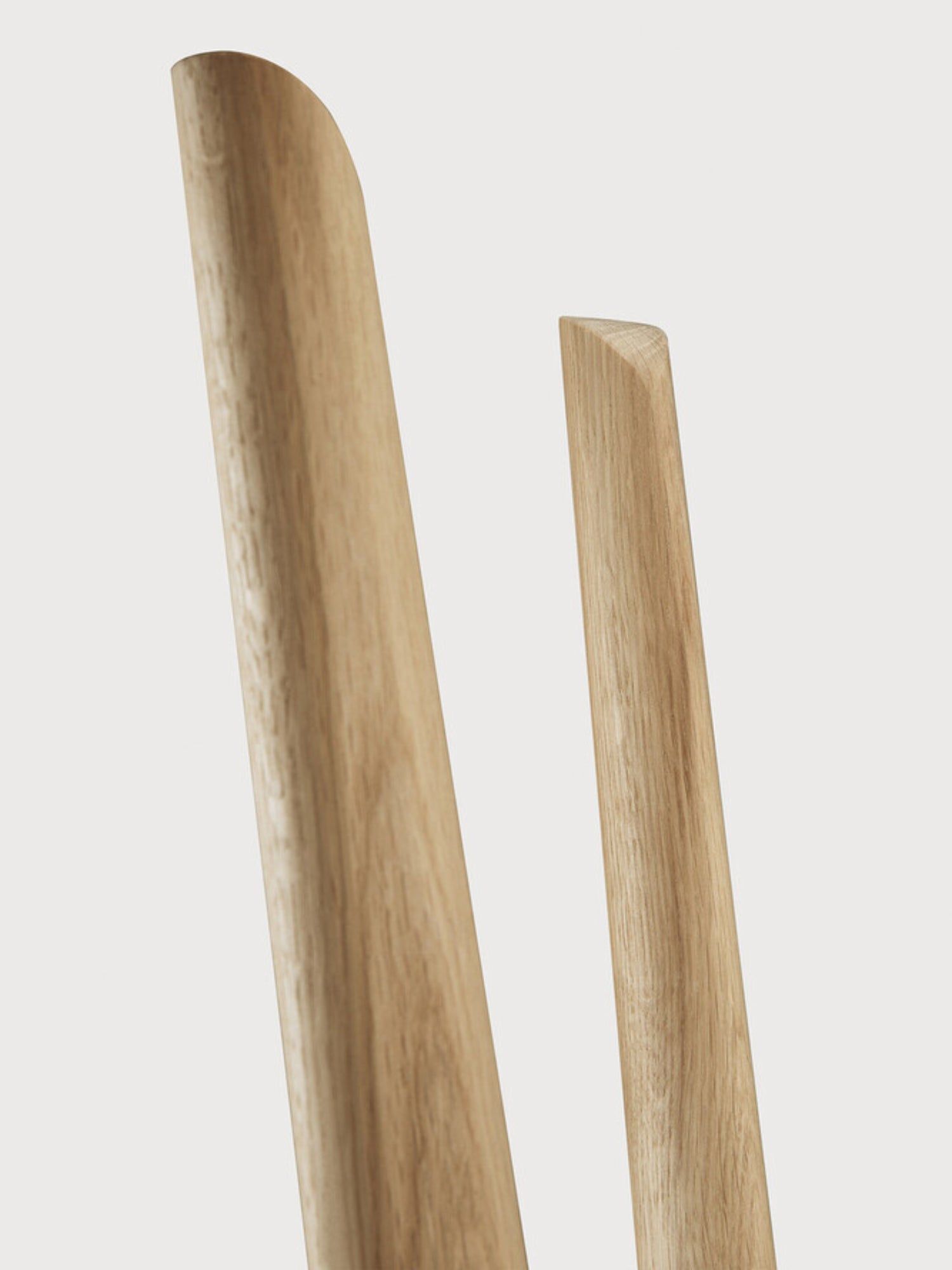 Ethnicraft PI Coat Stand, a modern minimalist coat rack crafted from natural solid oak with a smooth wood grain finish, featuring slender, rounded wooden poles with distinctively curved and angled tops. This elegant Scandinavian-inspired piece is perfect for an entryway, hallway, or bedroom, offering stylish storage for contemporary organic modern interiors.