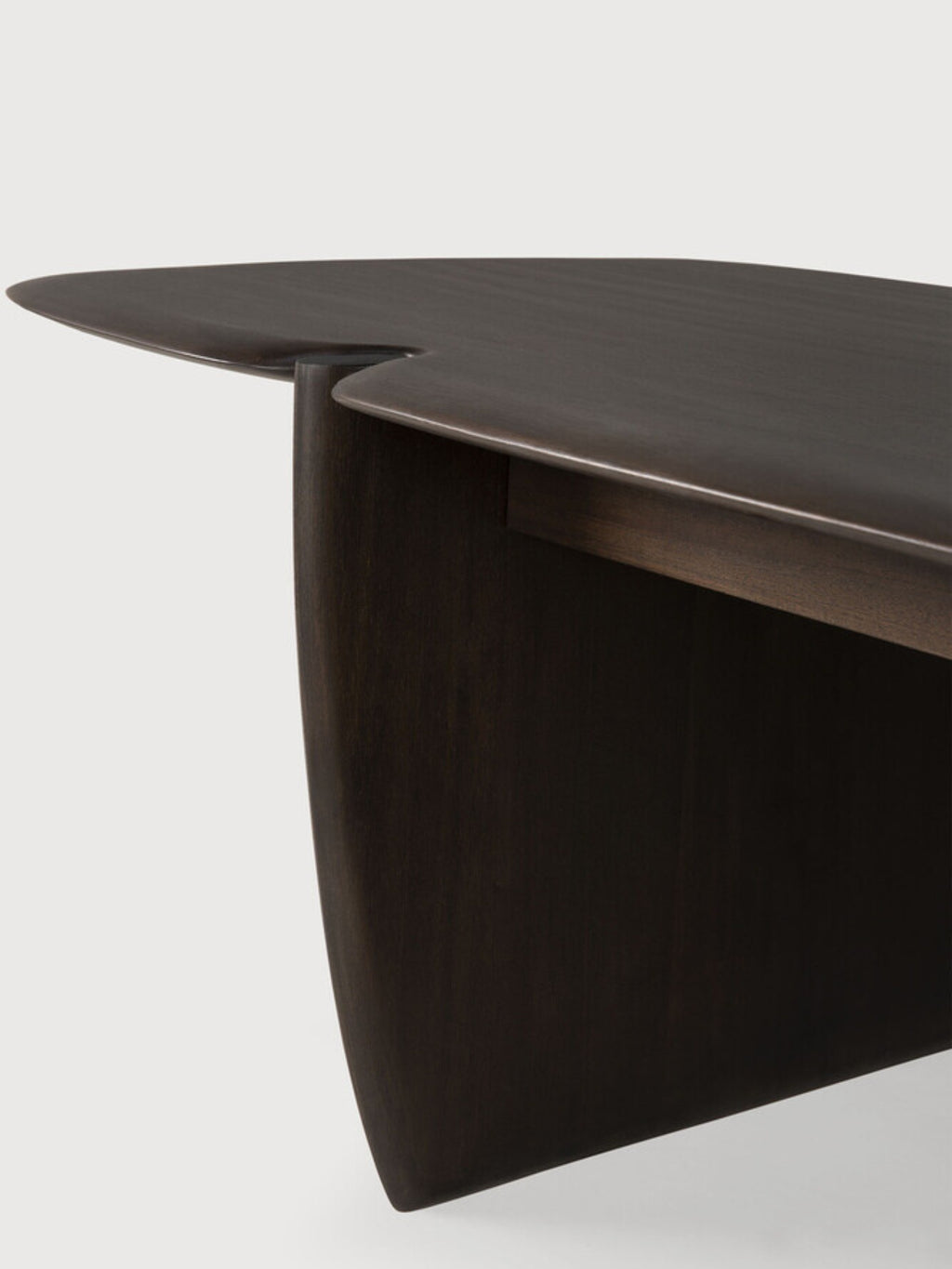 Ethnicraft PI Coffee Table, a detailed close-up of the dark brown mahogany rectangular wooden coffee table, highlighting its smooth, curved edges and the seamless joinery of its unique base.