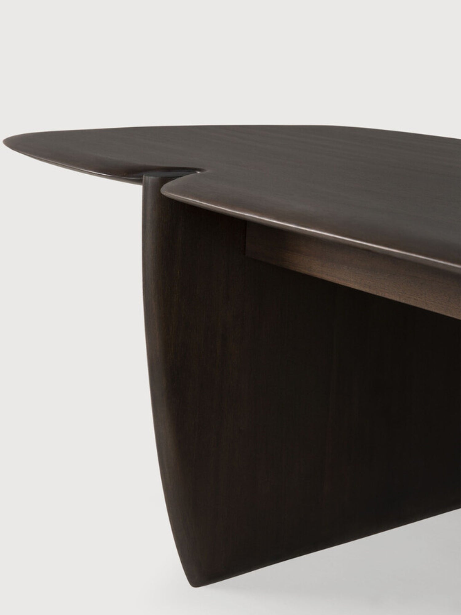 Ethnicraft PI Coffee Table, a detailed close-up of the dark brown mahogany rectangular wooden coffee table, highlighting its smooth, curved edges and the seamless joinery of its unique base.