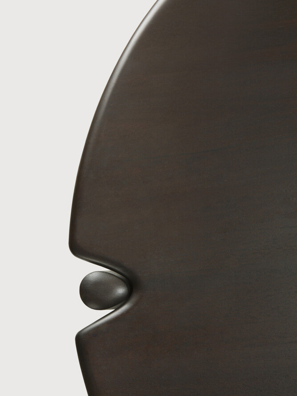 Ethnicraft PI Coffee Table, an extreme close-up of the dark brown mahogany round wooden coffee table, showcasing the intricate detail of its tabletop edge and the subtle, elegant connection to its base.