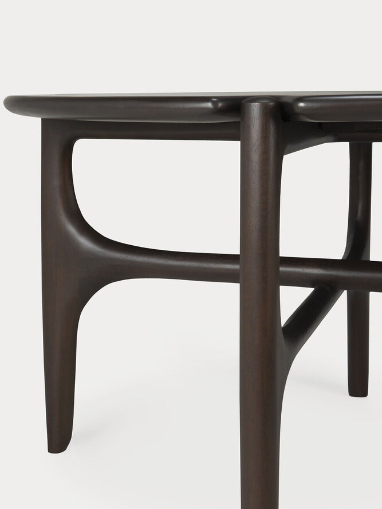 Ethnicraft PI Coffee Table in Mahogany Dark Brown. Close-up of the table's side, revealing the smooth, curved, and sculptural mahogany wood legs and frame, showcasing the rich dark brown finish and organic, modern design.