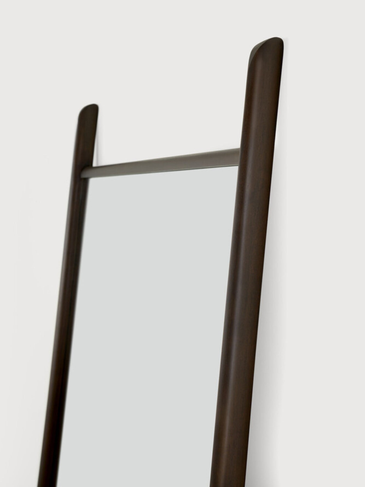 Ethnicraft PI Floor Mirror, a full-length modern minimalist leaning mirror featuring a dark brown solid wood frame with rounded, organic edges and a sleek dark metal accent bar. This contemporary wood floor mirror is perfect for adding functional style to a bedroom, entryway, or modern living room.